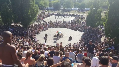 Large crowd around karaoke pit, Mauerpark, man sings into mic in middle, Berlin Видео 77409857