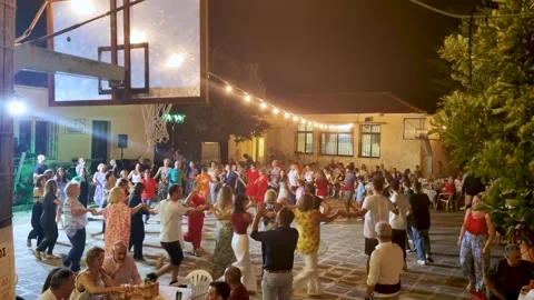 Large Crowd Dancing Traditional Greek Folk Dance in Circle at Night Panigiri Stock Footage 336420245