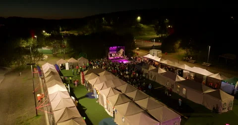 A Large Crowd Gathers Around Illuminated Tents and a Stage During the Relay For Stock Footage 328402981