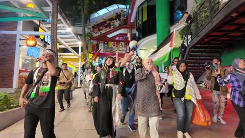 Large crowd marching with Palestinian flags down a major KL street Video stock 318095716