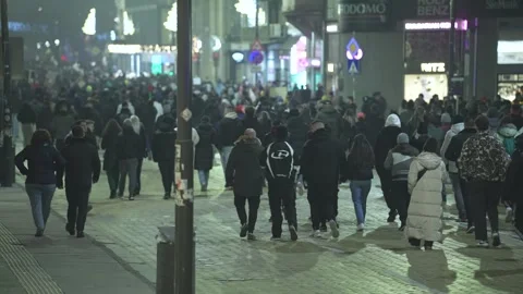 A large crowd moves along a central boulevard in nighttime Sofia Stock Footage 324556474