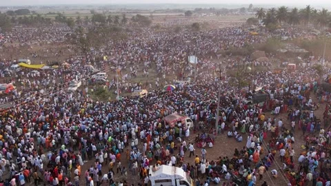 Large crowd of people moving on roads and farmlands during a religious event Stock Footage 233506195