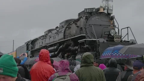 A large crowd of people in the rain to see the Big Boy Train Stock Footage 332618814