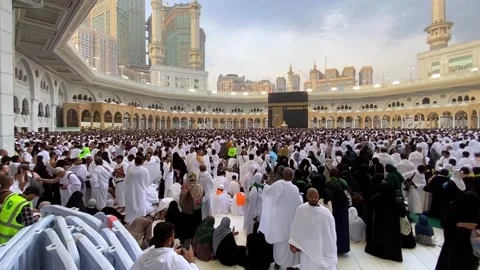 A large crowd of pilgrims dressed in ihram garments performing rituals at the 스톡 동영상 347979225