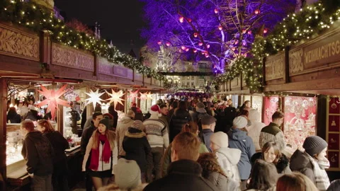 A large crowd walks between illuminated wooden stalls Stock Footage 340281789