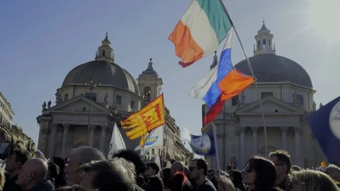 A large crowd waves flags in front of the twin churches. Stock Footage 99522558