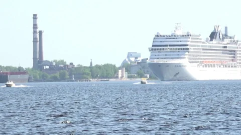 Large cruise ship sails on river blue water past green bank Stock Footage 110844958
