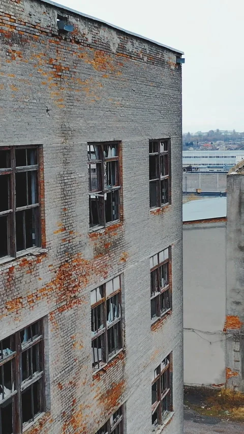 A large crumbling brick wall with broken windows. Industrial park. Aerial view. Video stock 269042633
