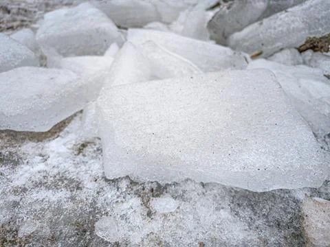 Large Crystal Ice Block Resting On Frozen Ground During Spring Thaw Stock Photos