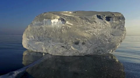 Large crystal ice block sitting on frozen lake surface at cold dawn. Stock-Footage 341241486