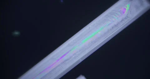 Large Crystal under Microscope 100x Magnification in Polarized Light on Dark Stock Footage 322601114