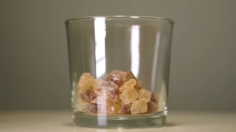 Large crystals of cane sugar or brown lump caramelized saccharose in glass Stock Footage 75241487