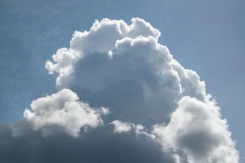 A large cumulus cloud in a blue sky with cirrus clouds. Foto stock