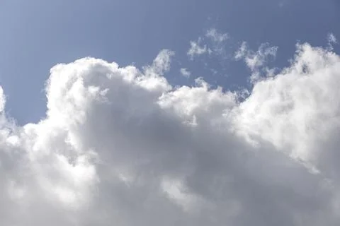 Large cumulus cloud dominates blue sky in bright summer daylight. Puffy white Stock Photos