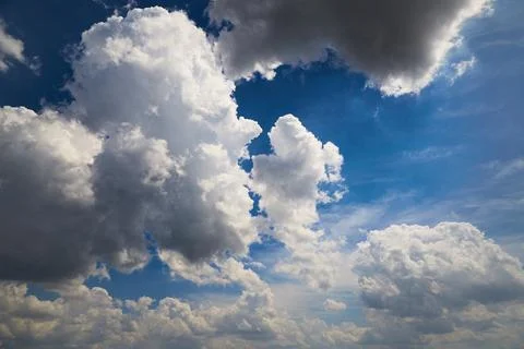Large cumulus clouds in the blue sky close-up, weather change, variable cloud Stock Photos