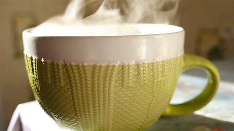A large cup of tea is on the table. Transparent steam. Slow Motion Stock Footage 91584769