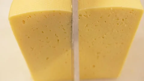 Large cutter cuts a piece of cheese Stock Footage 169518088