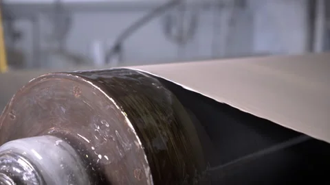 Large cylindrical roller creates smooth material surface Stock Footage 303104514
