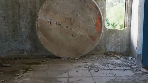 Large cylindrical tank abandoned in deteriorated concrete room with window Video stock 342087554