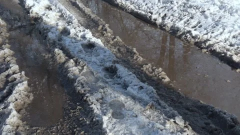 Large dark puddle on a slushy snowy winter road Stock Footage 325183394