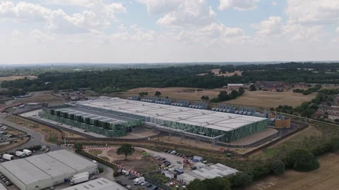A large Data Center complex sits in a rural area surrounded by green fields and Stock Footage 347349205