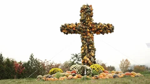 A large decorative cross constructed from various gourds and squashes, surrounde Stock Footage 289655708