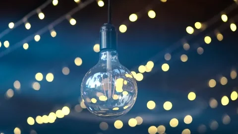 A large decorative light bulb against a backdrop of colorful lights Video stock 274062229