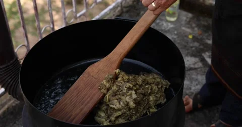 A large deep pot on a hot fire, while pouring finely chopped eggplant into it. Stock Footage 207718020