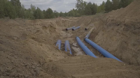 Large diameter pipes lie in dug up ditch for repairing works Stock-Footage 275645153