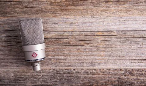 Large diaphragm condenser studio microphone Neumann tlm 103 on a wooden Stock Photos