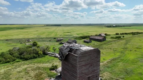 Large, dilapidated grain elevator sits in a field Stock Footage 313810573