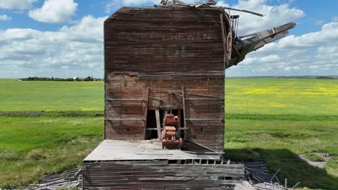 Large, dilapidated grain elevator sits in a field 库存影片 313810578