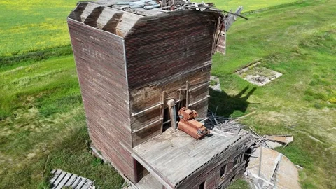 Large, dilapidated grain elevator sits in a field 库存影片 313810593