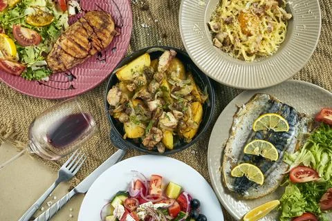 Large dining table with various dishes - baked potatoes with chicken, carbona Stock Photos