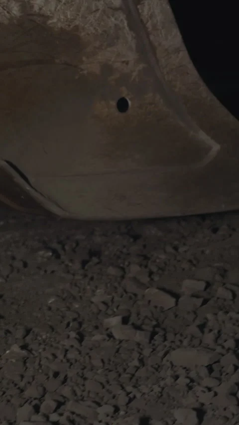 Large dipper of heavy machine scooping up black ore in mine Stock Footage 309050032