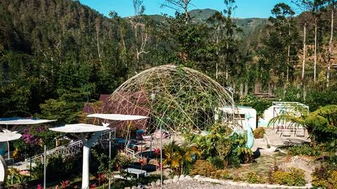 A large dome-shaped structure sits in a lush green garden Stock Photos