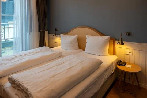 Large double bed bedside tables and lamps in the hotel room. Stock Photos