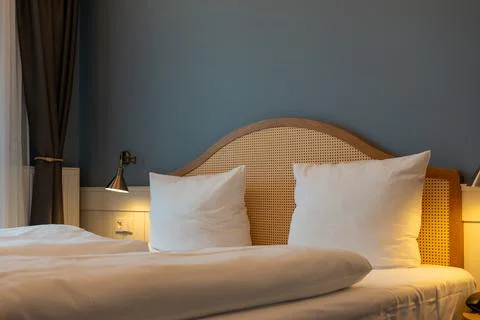 Large double bed bedside tables and lamps in the hotel room. Stock Photos