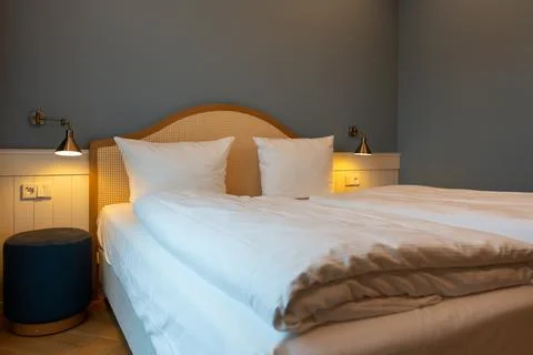 Large double bed bedside tables and lamps in the hotel room. Stock Photos