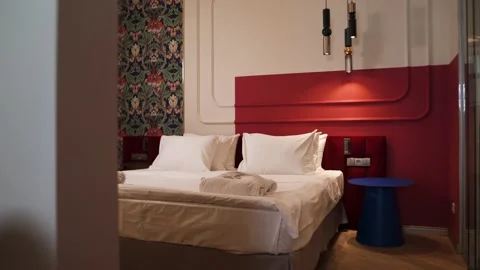 Large double bed in an elite hotel against the background of a red wall Stock Footage 164559402