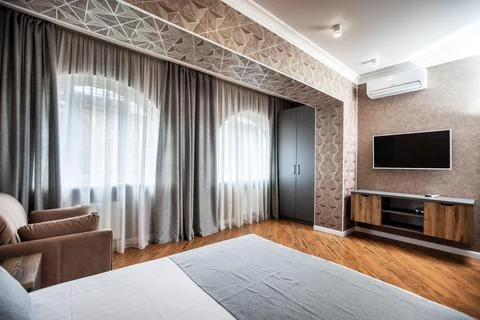 A large double bed with pillows in the bedroom in the apartment. in a gray-wh Stock Photos