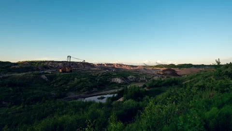 Large dragline excavator working in an open‑pit mine under blue sky. Timelapse Stock Footage 345370182