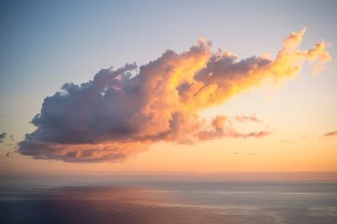 Large dramatic cumulus cloud illuminated in vivid orange and golden tones Foto stock