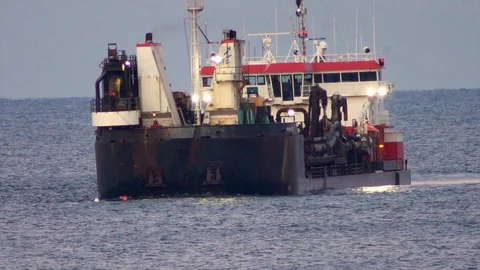 Large dredging ship connects with dredging pipe on ocean to pump sand on Stock Footage 119997540
