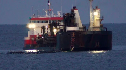 Large dredging ship connects with dredging pipe on ocean to pump sand on Stock Footage 119997998
