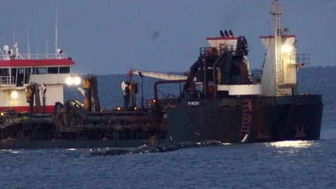 Large dredging ship connects with dredging pipe on ocean to pump sand on Stock Footage 119998021
