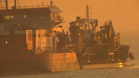 Large dredging ship operating early during sunrise. Video stock 119993608