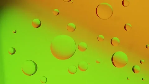 A large drop connects to a smaller drop on a yellow-green gradient background. 動画素材 303058877