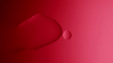A large drop flows and connects with another on a red gradient background 스톡 동영상 303060988