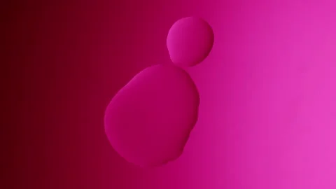 A large drop will connect with a smaller one on a pink gradient background Видео 303061064